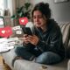 Mulher chorando sentada no sofá, segurando o celular, com aliança de casamento no chão e ícones de curtida do Instagram, sugerindo exposição do ex nas redes sociais.